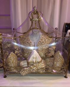 a bed that has some gold decorations on top of it and lights in the background