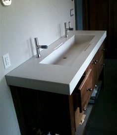 a bathroom sink sitting under a mirror next to a wall mounted faucet in a bathroom