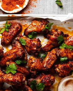 chicken wings with cilantro and parsley in a baking dish on a table