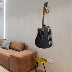 a guitar hanging on the wall next to a couch