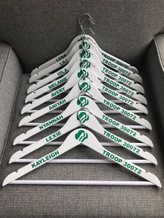 a bunch of white hangers with green stickers on them sitting on a couch