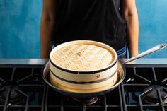 a person standing in front of an oven with a pan on it