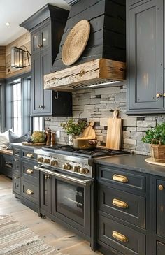 a kitchen with black cabinets and gold handles on the stove top, along with an oven