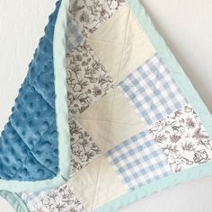 a blue and white quilt hanging on the wall