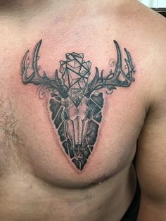 a man's chest with a deer skull and geometrical design on the side