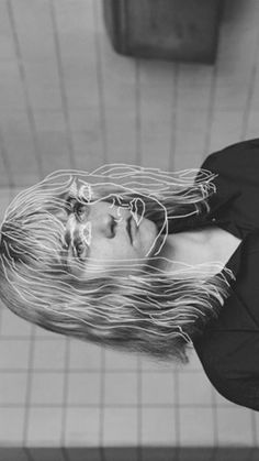 a black and white photo of a woman's head with long hair in the air