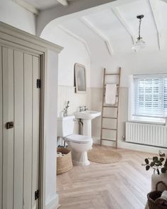 a bathroom with white walls and wooden floors