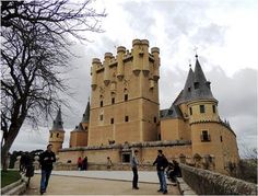 people are standing in front of an old castle