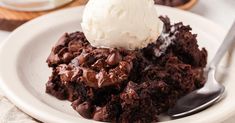 a white plate topped with brownies and ice cream on top of a wooden table