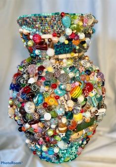 a vase filled with lots of different colored beads