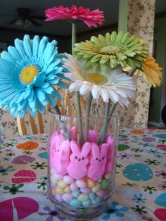 there are flowers in the vase with peep holes on it and candy inside them