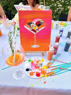 a woman sitting at a table with art supplies