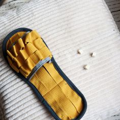 a pair of yellow slippers sitting on top of a bed