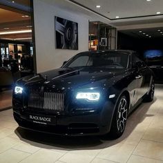 a black rolls royce parked in a showroom