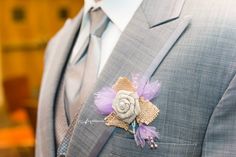 a man wearing a suit and tie with a boutonniere on his lapel