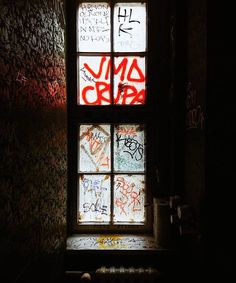 a window with graffiti written on it in a dark room