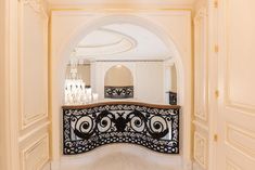 an ornate balcony with chandelier and marble flooring is seen through the archway