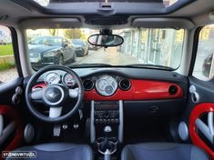 the interior of a small car with red trim and black leather seats is seen from the driver's point of view