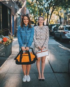 two women walking down the street with their bags