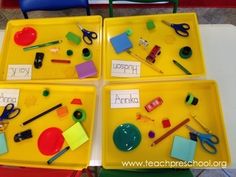 four yellow trays filled with different types of school supplies on top of a table