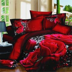 red rose bedding set with black and white flowers on the bottom, in a bedroom