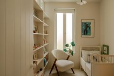 a baby's room with a crib, rocking chair and bookshelf