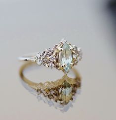 an engagement ring with two stone accents on the side, sitting on top of a table