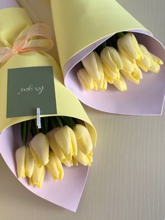 two bouquets of yellow tulips wrapped in paper