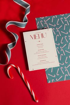 a candy cane next to a menu on a red table