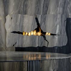 a large bird flying over a table in front of a stone wall with lights on it