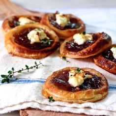 small pastries are sitting on top of a napkin with some garnishes