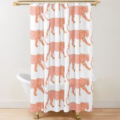 a shower curtain with an orange tiger on it's face and legs, in front of a white bathtub