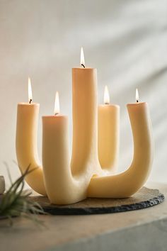 five candles are arranged in the shape of a candle holder on top of a table