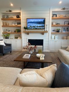 a living room filled with furniture and a flat screen tv mounted on the wall above a fireplace