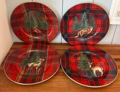 three red plaid plates with deer and trees on them