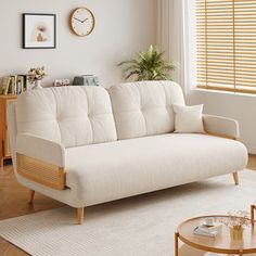 a living room with a white couch and wooden coffee table in front of a window