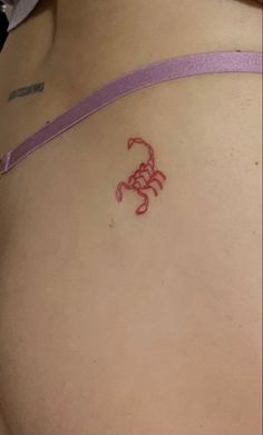 a small scorpion tattoo on the back of a woman