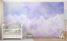 a baby's room with clouds painted on the wall and a crib next to it