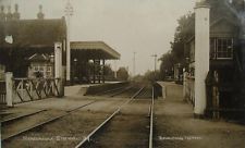 an old black and white photo of a train station with tracks in the foreground