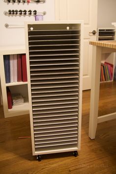 a room with a desk, bookshelf and other items on the floor in front of it