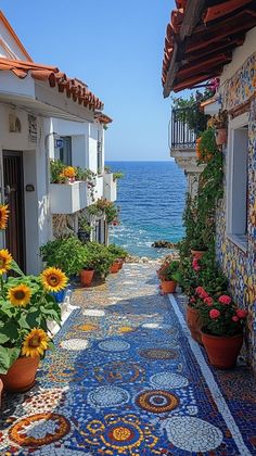 an alley leading to the ocean with sunflowers and potted plants on either side