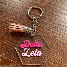 a clear acrylic keychain with the words delta letta on it