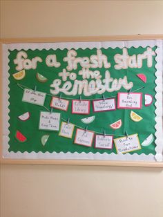 a bulletin board with fruit and words on it, hanging from the side of a wall