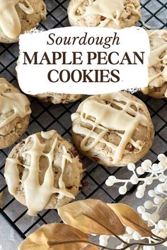 some cookies that are sitting on a cooling rack with frosting and leaves around them