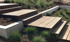 several wooden steps leading up to the top of a hill with grass growing on it