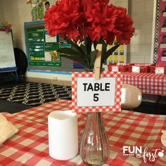 a table with a sign that says table 5 on it and some flowers in a vase