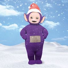 a purple stuffed animal with a santa hat on standing in the middle of a snow covered field