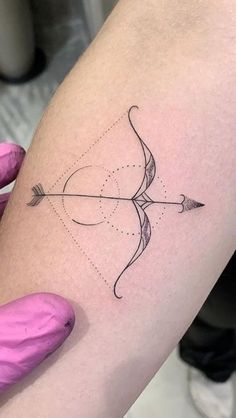 a woman's arm with an arrow tattoo on it