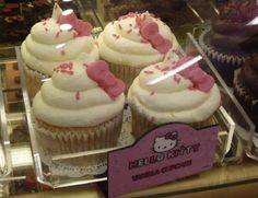 hello kitty cupcakes with white frosting and pink sprinkles on them