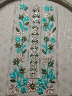 an embroidered piece with flowers and leaves on it